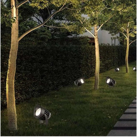 AC85‑265V IP65 Rotatable LED Flood Light (Green 25w) illuminating a garden path beside trees at dusk.