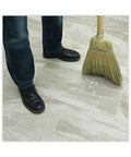 Reliable Workhorse Warehouse Brooms Crafted With Heavy Duty Corn Fiber Bristles For Ridiculously Fast Dust Removal Along With A Balanced Fifty Six Inch Overall Length To Keep Any Commercial Floor Looking Crisp Without Breaking A Sweat Daily. A person sweeping broken pieces on a commercial floor.