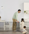 Heavy Metal Super Wide Baby Gate Expands To 192 Inches For Massive Openings with parents and children in a home setting.
