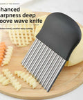 Front view of stainless steel crinkle cutter with black handle, used for slicing potatoes and carrots
