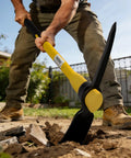Person using Heavy Duty Forged Steel Pick Axe With Shock Absorbing Fiberglass Handle For Digging And Chiseling In Hard Ground Concrete