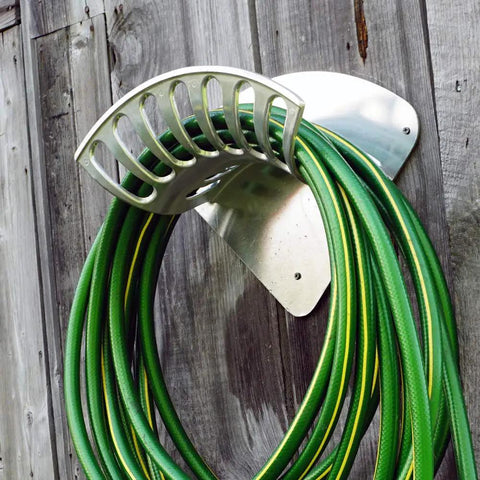 Heavy Duty 13 Inch Cast Aluminum Hose Rack For Outdoor Walls, Curved Wall Mount Hose Holder with green hose attached.