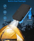 All-In-One Solar Power Bank 49800mAh With 4 Built-In Cables And 3 Foldable Panels, 22.5W PD, illuminating flashlight on tent