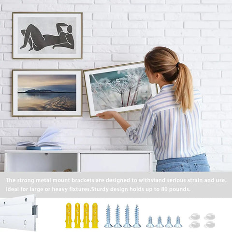 Woman hanging frames on a wall using Top Shelf Aluminum French Cleat Hanger Heavy Duty Wall Mount Kit For Mirrors Cabinets Shelves And Large Wall Art Two Pair Twelve Inch Span Eighty Pound Legit Strength Rock Solid Grip No Sweat Install For Basement Or Home Workspaces.
