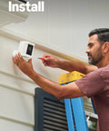Ring Spotlight Cam Plus Battery outdoor security camera, white, being installed on exterior wall