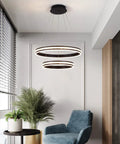 Modern Crystal Chandelier With Dimmable LED Pendant Light In Black, Acrylic Double Ring Design, in a living room setting