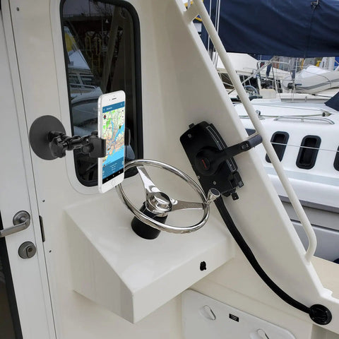 Heavy Duty Magnetic Phone Mount For Trucks, Tractors, Forklifts And Boats, Fits 3.5 To 7.5 Inch Smartphones, shown on boat helm