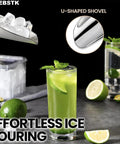 U-shaped ice shovel pouring ice into green cocktail with limes on table