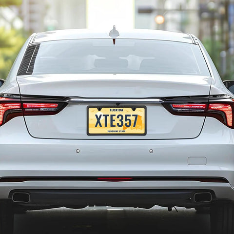 Rear view of a car showcasing Stainless Steel License Plate Frame With Slim Two Hole Design Flat Plate Holder That Keeps It Clean And Rust Free Weatherproof Car Accessory With Metal Screw Caps Black Finish Narrow Frame For Standard Plates.
