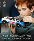 Child holding Next Gen NASCAR Chevrolet Camaro ZL1 Race Car Build Kit For Kids 9 And Up Collectible Model Toy with realistic details