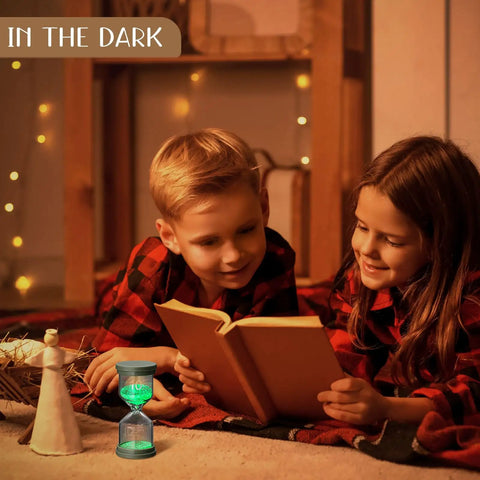 Children reading with Nine Colorful Luminous Sand Timers Set in background, glow-in-the-dark hourglasses for cozy home vibe.