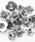 Premium Heavy Duty Stainless Steel Tee Nuts With Badass Four Prong Grip For Cabinetry Furniture And Rock Climbing Projects Featuring No Sweat Assembly In 1/4 5/16 And 3/8 Inch Sizes - assorted sizes in a pile.