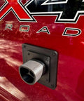 Fake EV Charging Port Magnet Snap On For Diesel Gas ICE Truck Gag Accessory mounted on a red truck near its logo.