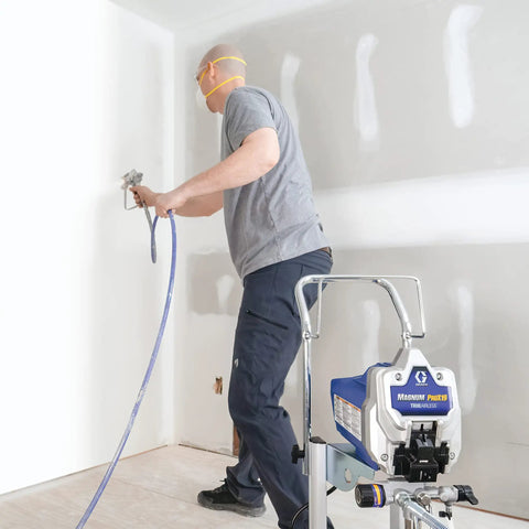 User operating Heavy Duty Cart Paint Sprayer With Full Control Flow And RAC IV Switchtip For Thick Coatings in a room.
