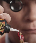 Close-up of applying super glue to a miniature model with precise dispensing tool