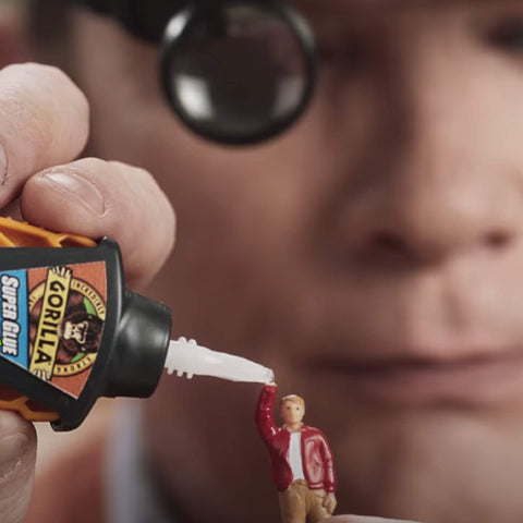 Close-up of applying super glue to a miniature model with precise dispensing tool