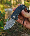 Hand holding Damascus Steel Pocket Folding Knife With 2.45 Inch Razor Sharp Blade Handmade Craftsmanship Stabilized Wood Handles