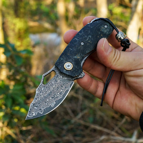 Hand holding Damascus Steel Pocket Folding Knife With 2.45 Inch Razor Sharp Blade Handmade Craftsmanship Stabilized Wood Handles