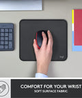 Hand using mouse on Studio Series Mouse Pad With Anti Slip Rubber Base, Spill Resistant Surface, Portable Desk Mat In Graphite