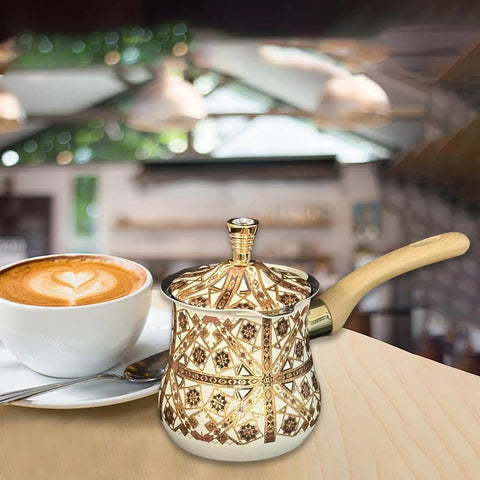 Stainless Steel Turkish Coffee Pot With Long Wooden Handle, Brown Pattern, Multipurpose Kitchen Accessory beside a coffee cup