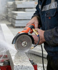Heavy Duty Angle Grinder Water Attachment With Brass Adjustable Nozzle And Flexible Hose For Dust Suppression and Slick Wet Cutting Tile Work That Runs Nice And No Sweat, in use with water spray on granite.