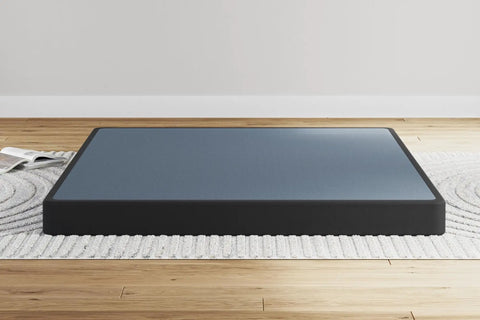 Rock Solid Queen Bed Foundation With Hefty Metal Frame And Modern Five Inch Box Spring Base Featuring Snug Gray Fabric Cover close-up on a rug.