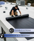 Man installing Top Shelf 45 Mil EPDM Rubber Roofing Membrane 5 Ft By 45 Ft on a flat roof, showcasing its flexibility and strength.