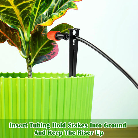 100 Pack Drip Irrigation Stakes For One Quarter Inch Tubing in use with green pot, securing tubing for plant watering