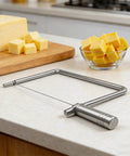 Rock Solid Stainless Steel Cheese Slicer Accessories For Hard Cheddar And Butter No Sweat Wire Cutter on countertop with cheese.