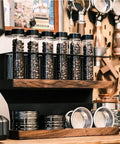 Transform Your Counter Into A Lowkey Essential Coffee Bar With This Badass 2 Tier Organizer Stand Built On Solid Wood And Carbon Steel Frame Holds 12 Airtight Bean Canisters One Way Valves Plus Pour Funnel, showcasing coffee bean canisters and a pour funnel.