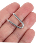 Close-up of a silver iron staple in hand, part of 50 Piece U Shaped Fencing Staples For Heavy Duty Iron Garden Nails Quick Install Sharp Tip