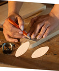 Hands using orange pencil to mark wood while preparing to use Knockout 100 Piece Wood Biscuit Joiner Kit With Heavy Duty Biscuit Cutter.