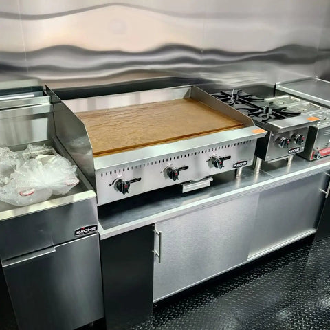 Custom Rollout Food Trailer Kitchen Unit Featuring Heavy Duty Refrigerator Commercial Sink And Stainless Steel Juicer Station Ideal For Coffee Kiosks Ice Cream Booths And Street Snacks Ready To Hustle Urban Pavement Daily - stainless steel grilling area with burners and refrigerator.