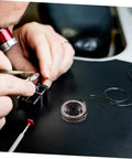 Person repairing clock with Pro Grade Mechanical Alarm Clock Repair Kit With Precision Springs, showing gears and tools.