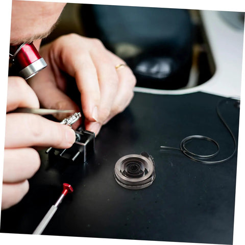 Person repairing clock with Pro Grade Mechanical Alarm Clock Repair Kit With Precision Springs, showing gears and tools.