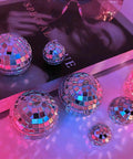 24 Pcs Mirror Disco Balls Hanging Set In Four Sizes 2.4 Inch, 2.0 Inch, 1.6 Inch, 1.2 Inch, Silver Glass Ball Ornaments On Table