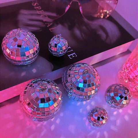 24 Pcs Mirror Disco Balls Hanging Set In Four Sizes 2.4 Inch, 2.0 Inch, 1.6 Inch, 1.2 Inch, Silver Glass Ball Ornaments On Table