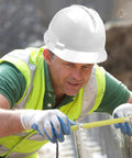 Construction worker wearing white hard hat measuring, showcasing Customizable Safety Hard Hat With Personalized Logo For Construction And Work.