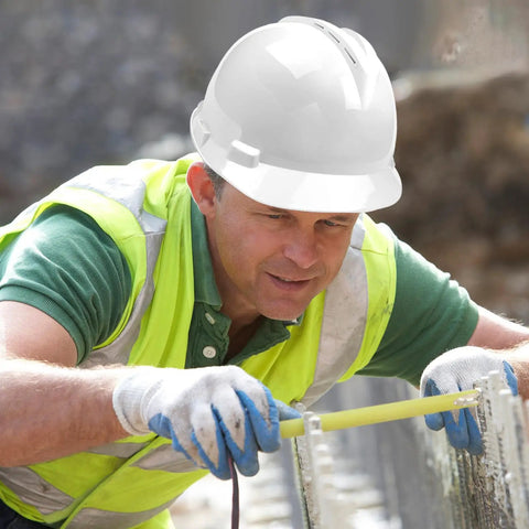 Construction worker wearing white hard hat measuring, showcasing Customizable Safety Hard Hat With Personalized Logo For Construction And Work.