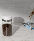 Keep Your Beans Fresh As A Daisy With This Smart Electric Vacuum Seal Coffee Canister And Airtight Storage Jar For Whole Ground Roasts Real Deal Smooth Push Button Operation Durable Borosilicate Glass with coffee beans.