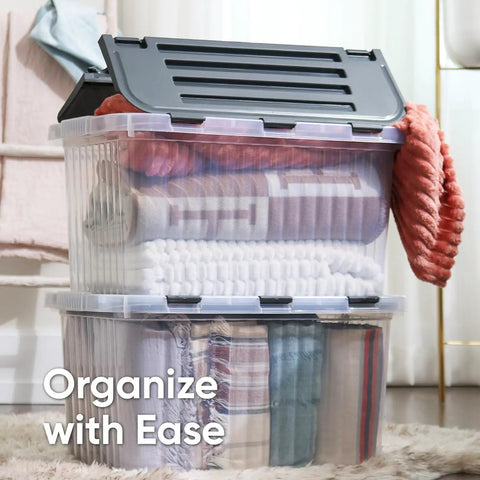 12 Pack Heavy Duty Clear Deep Storage Containers With Secure Hinged Lids 27.5 Quart Snap Close Bins stacked with blankets and towels.