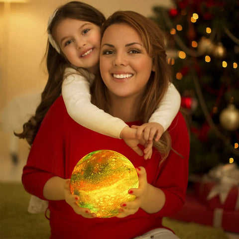 Mother and daughter holding 7.1 Inch Galaxy Moon Lamp 3D Printed Moon With NASA Imagery, glowing in cozy living room