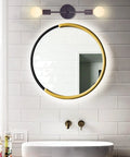 Dual Light Bathroom Wall Sconce Vanity Fixture In Gold And Black Finish installed horizontally over a round mirror in a bathroom.