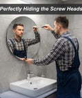 Man installing Heavy Duty Mirror Screw Caps With Stainless Steel Decorative Hardware Slick Silver Covers And Copper Silicone Washers Top Shelf Furniture And Glass Sign Fittings Built Like A Tank onto a round mirror.