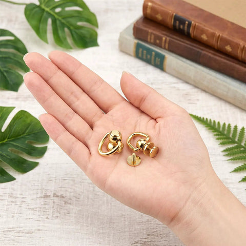 Top Shelf Gold Brass D Rings For Purse 4 Pack With Screw Back Rotatable Strap Hardware Absolutely Solid Build showing two rings in hand.
