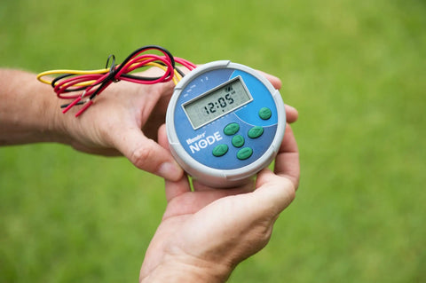 Node 200 Battery Operated Sprinkler Timer For 2 Zone Waterproof Irrigation Controller shown held in hand on grass background.
