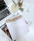 22 Pack White Rigid Mailers 9.25 X 11.5 Inches Heavy Duty Cardboard Mailers with documents on desk
