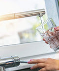 Two Pack Chrome Faucet Aerators 2.2 GPM Dual Thread For Male And Female Faucets shown in use filling a glass with water