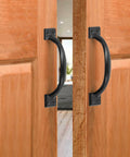 Vintage Inspired 5.5 Inch Black Curved Cabinet Door Handles Made From Solid Iron installed on wooden cabinet doors.