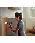 Person using V20 1/2 Inch Cordless Drill Driver Kit With Two Batteries And Charger For Fast Drilling And More Holes Per Charge on cabinet